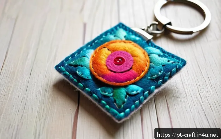 수공예 키링 만들기 - A detailed close-up of a handcrafted keychain made of soft felt fabric in vibrant colors, featuring ...